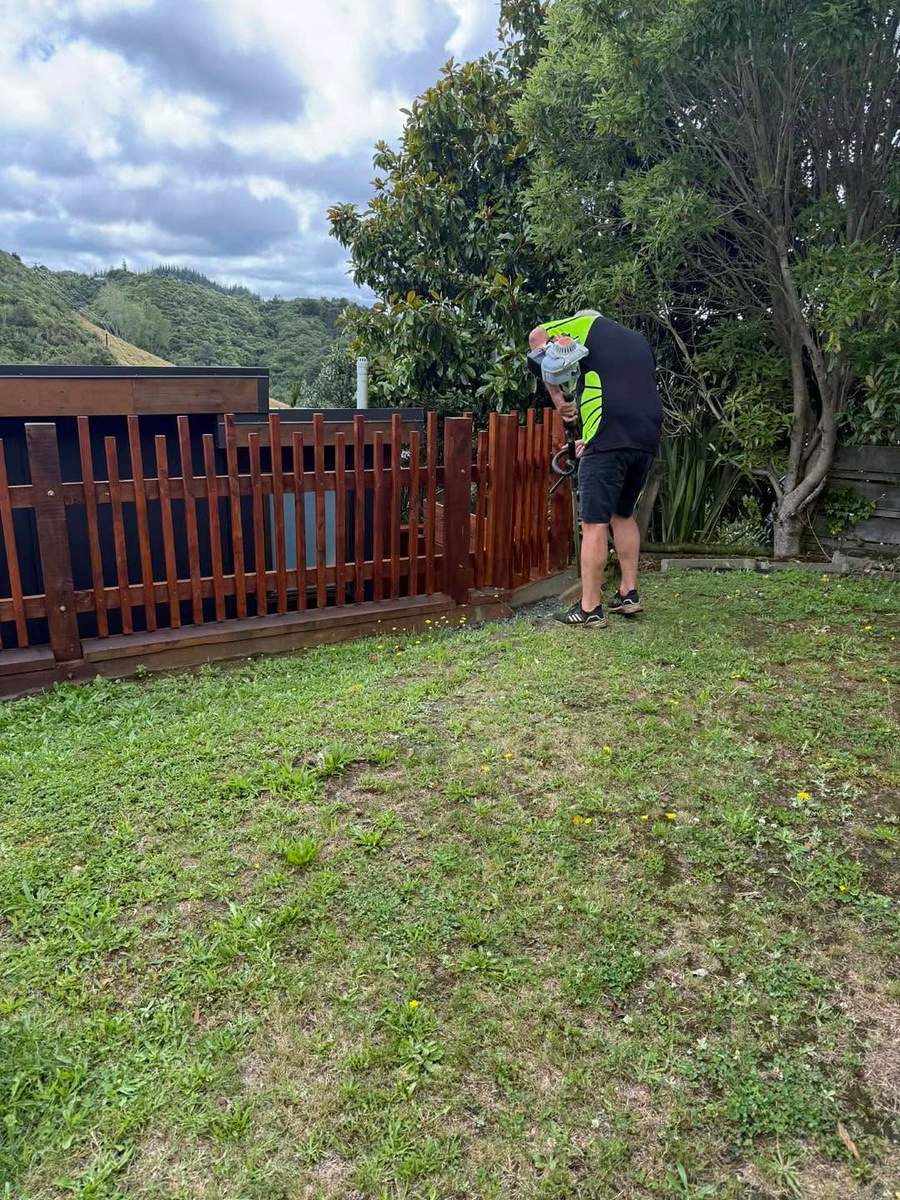 Trimming along a fence line with Marlborough hills behind