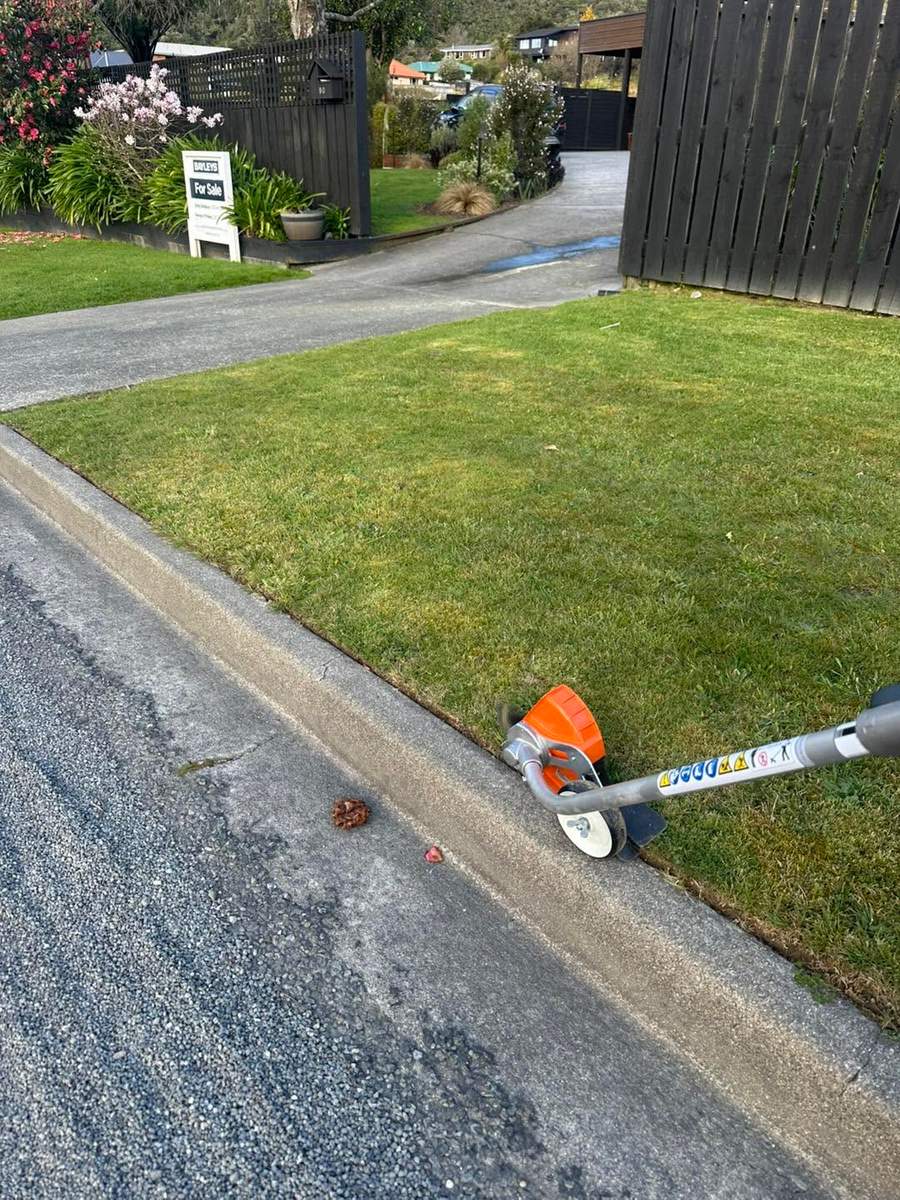 Trimming lawn edges along a driveway